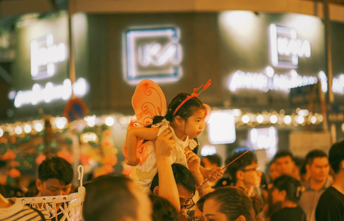 Una niña va sobre los hombros de su papá en medio del Festival del Medio Otoño